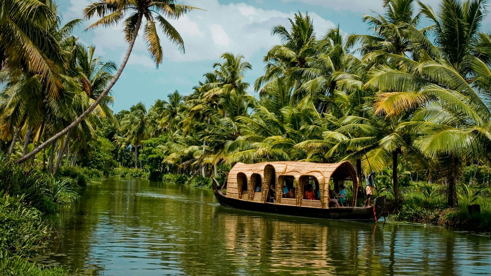 Houseboat en los backwaters de Kerala entre palmeras